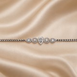 Celestial Dewdrop 925 sterling silver bracelet displayed on a luxurious beige satin background, showcasing pear-cut and baguette-cut sparkling stones.