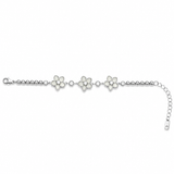 Moonlit Blossom 925 sterling silver bracelet featuring three floral motifs with sparkling AAA cubic zirconia stones and an adjustable chain, elegantly displayed on a luxurious beige satin background.