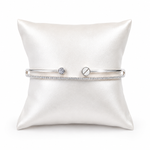 IRA Celeste Duo Bracelet in 925 sterling silver featuring a sleek open cuff design with sparkling cubic zirconia accents and a solitaire-inspired detail on a premium white display cushion.