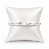 IRA Celeste Duo Bracelet in 925 sterling silver featuring a sleek open cuff design with sparkling cubic zirconia accents and a solitaire-inspired detail on a premium white display cushion.
