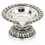 Mohnaa Shreekamal 925 sterling silver ornate diya featuring a scalloped decorative rim, polished bowl, and intricately patterned pedestal on a white background.