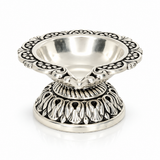 Mohnaa Shreepad 925 sterling silver decorative diya featuring an ornate scalloped rim, polished bowl, and intricately detailed pedestal base on a white background.

