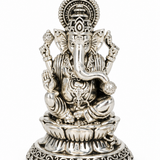 Traditional seated Lord Ganesha idol with ornate detailing and decorative lotus pedestal in silver finish