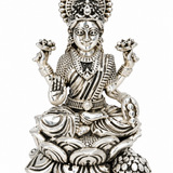 Goddess Lakshmi seated on an intricately detailed lotus throne with lotus flowers and decorative silver-finish detailing